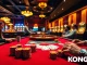 KONG88 poker players strategizing at a glamorous casino table with colorful chips and vibrant lights.
